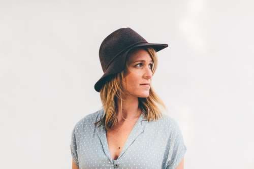 Woman wearing vintage style hat on a neutral background.