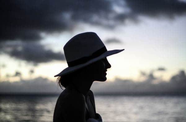 Elegance with a Hat Young woman with a wide-brimmed hat in an outdoor setting.